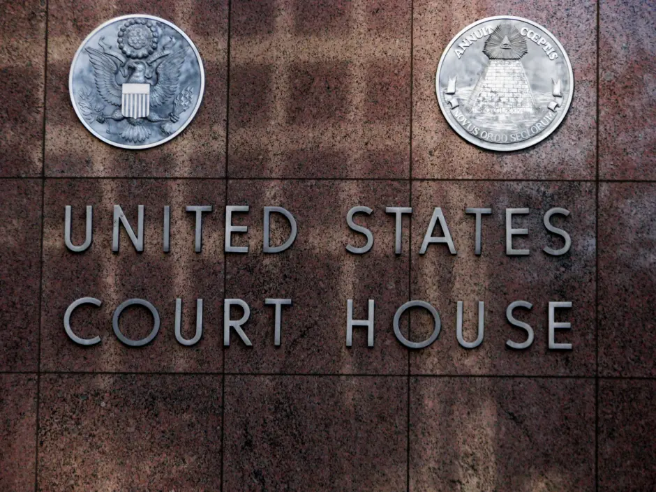 Imagen de una pared marrón con las palabras United States Court House en un lateral. 