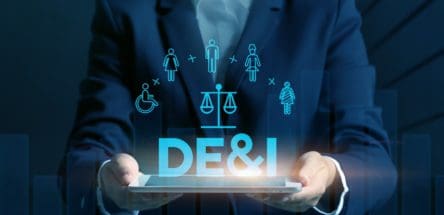 Picture of man in a blue suit holding a table that has DEI projecting from it.