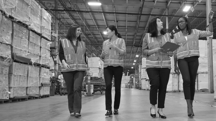 GEA_Kohler_SupplierDiversity_MatchMaker (003) Trabajadoras con chalecos caminando por la fábrica. Imagen en blanco y negro.