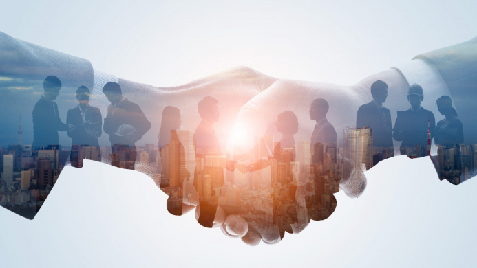 Partnership,Of,Business,Concept.,Business,Network. Image Description: Outline of two handshaking with an image projected onit including multiple people standing in front of the sun.